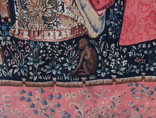 fig 3. A woven wall tapestry depicting a central female figure beside a tent inscribed Mon Seul Desir, surrounded by a lion, unicorn, and mille-fleurs background.