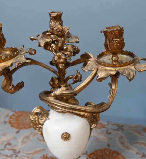 fig 1. A pair of late 19th-century French Louis XVI Revival gilt bronze and white marble three-arm candelabras featuring urn-shaped bases and floral branch detailing.