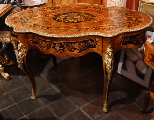fig 1. A French Louis XV style centre table featuring intricate floral marquetry, a serpentine top, cabriole legs, and gilded bronze mounts.