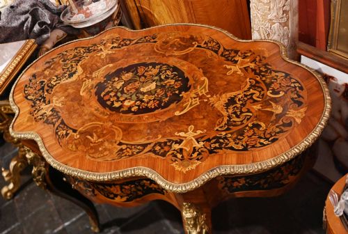 fig 3. A French Louis XV style centre table featuring intricate floral marquetry, a serpentine top, cabriole legs, and gilded bronze mounts.
