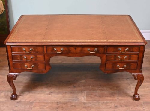 fig 2. Late Victorian mahogany writing desk featuring a tan gilt-tooled leather inset top, brass swan-neck handles, and carved cabriole legs with ball-and-claw feet.
