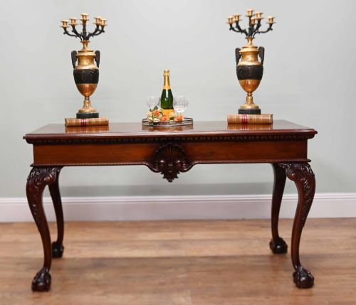 fig 1. A rectangular Chippendale revival mahogany console table featuring a central carved apron shell detail, cabriole legs, and carved claw and ball feet.