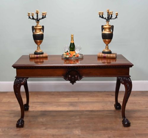 fig 2. A rectangular Chippendale revival mahogany console table featuring a central carved apron shell detail, cabriole legs, and carved claw and ball feet.