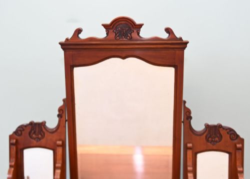fig 2. An Edwardian mahogany dressing table featuring a central swinging mirror flanked by two trinket drawers, set above a chest with three drawers and brass drop handles.