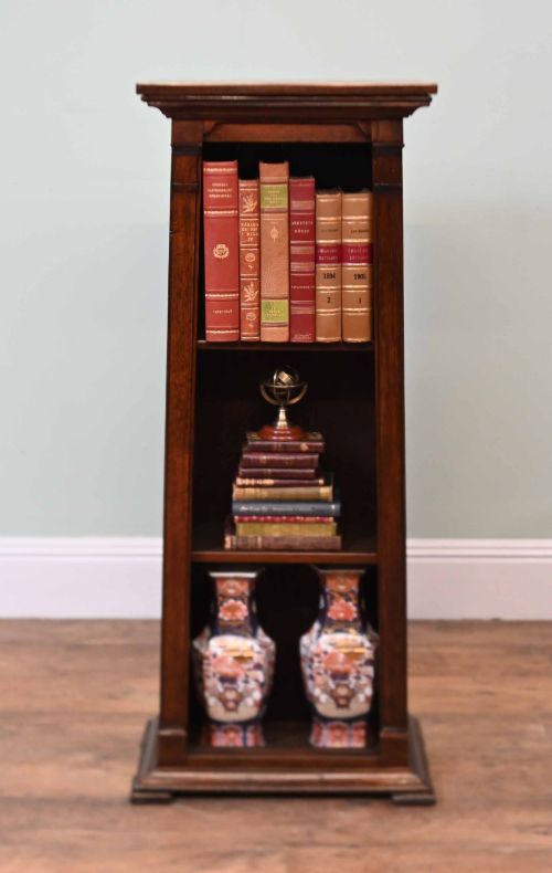 fig 2. A tall, narrow late 19th-century dark oak open bookcase featuring fixed shelves, a moulded top cornice, and a sturdy plinth base.