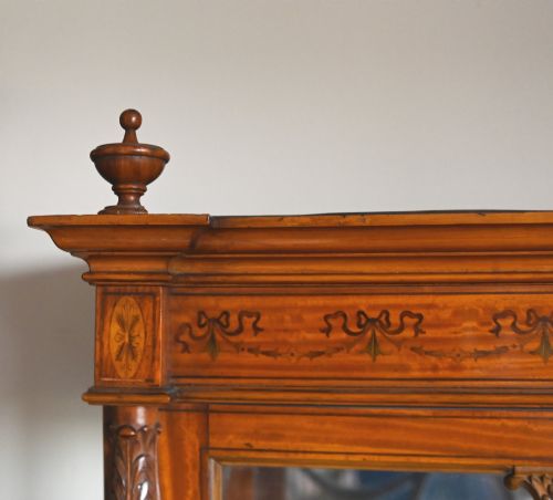 fig 2. An Edwardian Sheraton Revival display cabinet in painted satinwood with glazed double doors, decorative oval glazing bars, and lower cupboard doors on slender square legs.