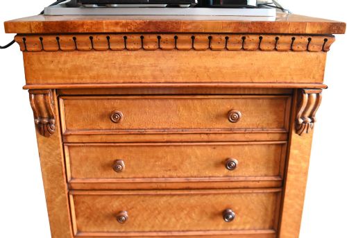 fig 1. A tall Victorian birds eye maple Wellington chest featuring seven drawers with turned wooden knobs and a side locking flap.