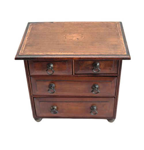 fig 2. A Georgian Revival mahogany apprentice chest featuring two small top drawers over two full-width drawers with brass drop handles and an inlaid top border.