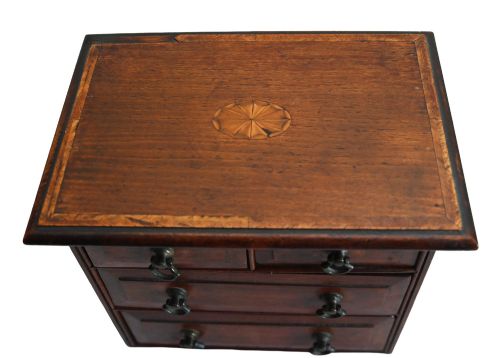 fig 3. A Georgian Revival mahogany apprentice chest featuring two small top drawers over two full-width drawers with brass drop handles and an inlaid top border.