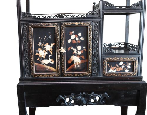 fig 1. An antique ebonised Chinese display cabinet featuring asymmetrical shelves, pierced fretwork, and panels decorated with mother-of-pearl crane and botanical inlays.