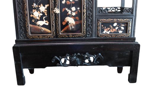 fig 2. An antique ebonised Chinese display cabinet featuring asymmetrical shelves, pierced fretwork, and panels decorated with mother-of-pearl crane and botanical inlays.