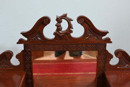 fig 2. A mahogany ladies writing desk featuring a red leather inset writing surface, a central mirror superstructure flanked by drawers, and turned legs on castors.