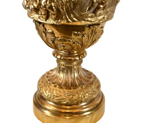 fig 2. A pair of 19th-century French gilt bronze ewers featuring detailed Bacchus relief scenes, leaf motifs, and cherub-topped handles.
