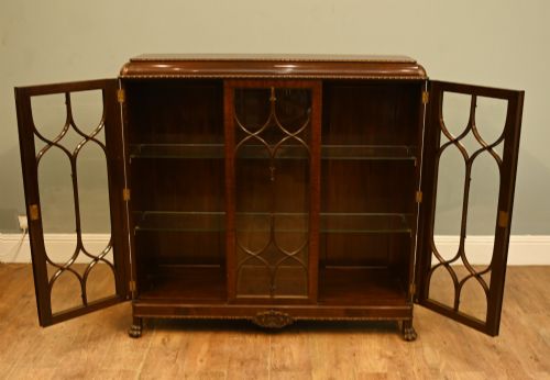 fig 2. A Chippendale Revival mahogany display cabinet featuring three astragal glazed doors and carved ball and claw feet.