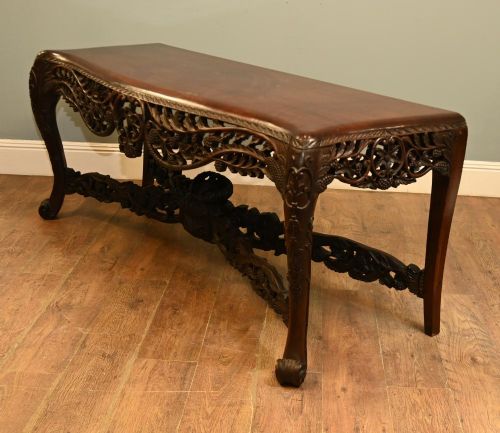 A dark hardwood Qing Dynasty console table featuring intricate carved openwork aprons and scrolled cabriole legs. View XIII