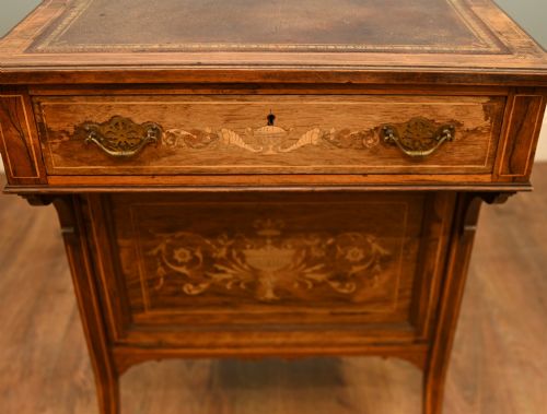 fig 3. An Edwardian mahogany Davenport desk with urn marquetry inlays, a leather writing slope, brass gallery rim, and legs on castors.