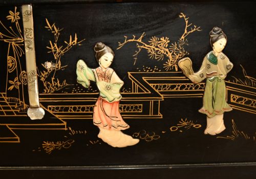 fig 1. A black lacquered rectangular wooden chest embellished with raised soapstone figures and landscape scenes, fitted with an etched brass lock plate.