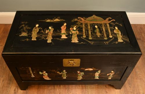 fig 4. A black lacquered rectangular wooden chest embellished with raised soapstone figures and landscape scenes, fitted with an etched brass lock plate.