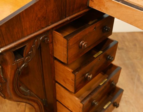 fig 2. A Victorian mahogany Davenport desk featuring a sloped leather writing top, carved cresting rail, serpentine front supports, and side drawers.