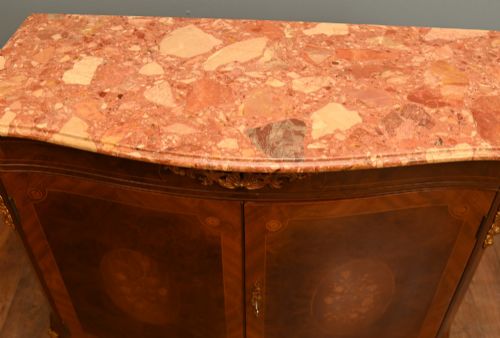 fig 2. A Louis XV Revival walnut side cabinet featuring a serpentine front, floral marquetry inlay, pink marble top, and gilt-bronze mounts on cabriole legs.