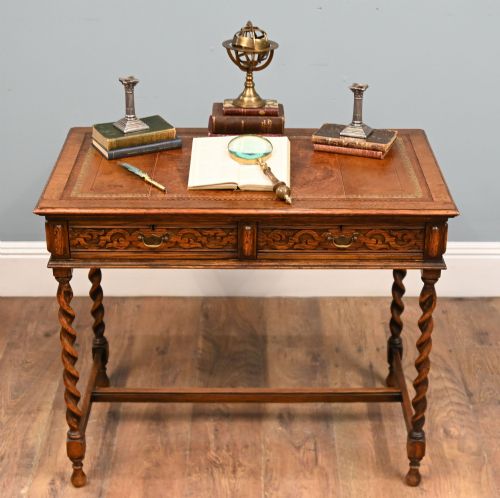 fig 1. A Victorian oak writing desk featuring barley twist legs, carved apron detailing, a leather inset writing surface, and an H-stretcher.