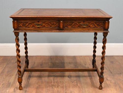 fig 2. A Victorian oak writing desk featuring barley twist legs, carved apron detailing, a leather inset writing surface, and an H-stretcher.