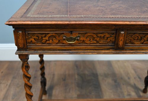 fig 3. A Victorian oak writing desk featuring barley twist legs, carved apron detailing, a leather inset writing surface, and an H-stretcher.