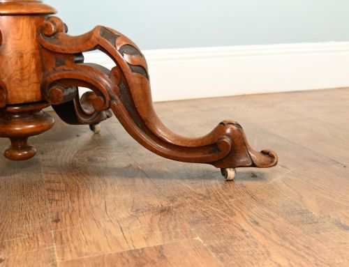 fig 1. A mid-19th-century Irish burr walnut centre table featuring a shaped serpentine top with a carved frieze set on a turned pedestal with four carved legs.