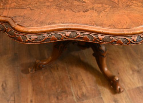 fig 2. A mid-19th-century Irish burr walnut centre table featuring a shaped serpentine top with a carved frieze set on a turned pedestal with four carved legs.