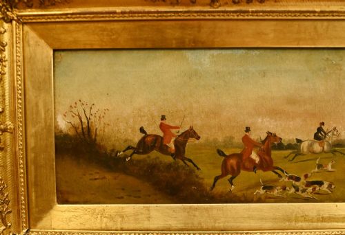 fig 3. A pair of horizontal antique Victorian oil paintings in ornate gold gilt frames depicting horseback riders and hounds in a field.