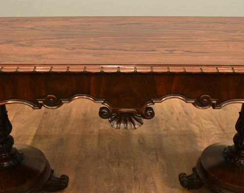 fig 1. A William IV mahogany library table with a carved apron, shell detail, twin pedestal end supports, and scroll feet.