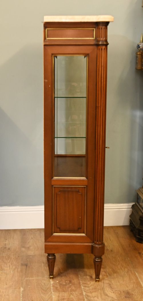 A French Directoire style mahogany vitrine cabinet featuring a single glazed door, fluted corner pilasters, brass line inlays, tapered turned feet, and a marble top surface. View IX
