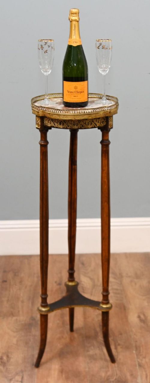 fig 1. A French Louis XVI style pedestal stand featuring a circular marble top with a pierced brass gallery, supported by three fluted legs and a lower tier.