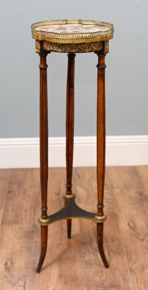 fig 2. A French Louis XVI style pedestal stand featuring a circular marble top with a pierced brass gallery, supported by three fluted legs and a lower tier.