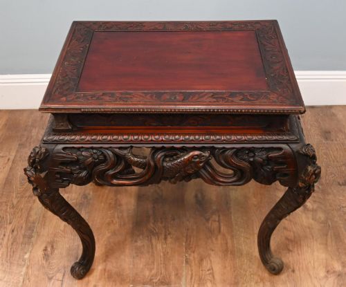 fig 1. A dark brown antique Japanese side table featuring intricate relief carvings along the apron and cabriole legs.