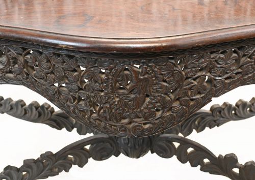 fig 1. A late 19th-century Burmese dark teak console table featuring intricately pierced foliate carvings on the gallery back, skirt, and cross-stretcher, supported by legs carved as mythical figures.