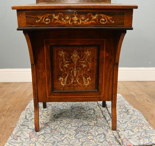 fig 1. A late Victorian Sheraton Revival davenport desk crafted from warm brown wood, featuring decorative marquetry inlay and a dark leather inset writing surface.