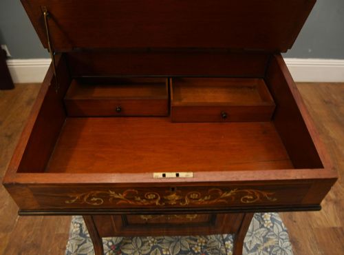 fig 4. A late Victorian Sheraton Revival davenport desk crafted from warm brown wood, featuring decorative marquetry inlay and a dark leather inset writing surface.