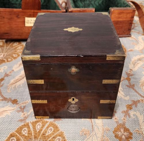 fig 3. A Victorian brass marine chronometer mounted inside a brass-bound dark mahogany box with a printed manufacturer label.