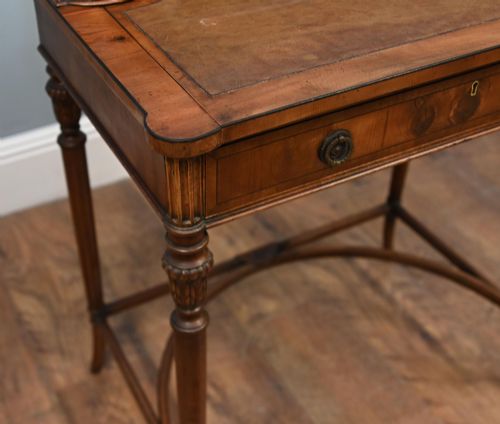 fig 2. A Regency Revival mahogany ladies writing desk featuring a leather-lined writing surface, elevated drawer superstructure, turned reeded legs, and a curved stretcher.