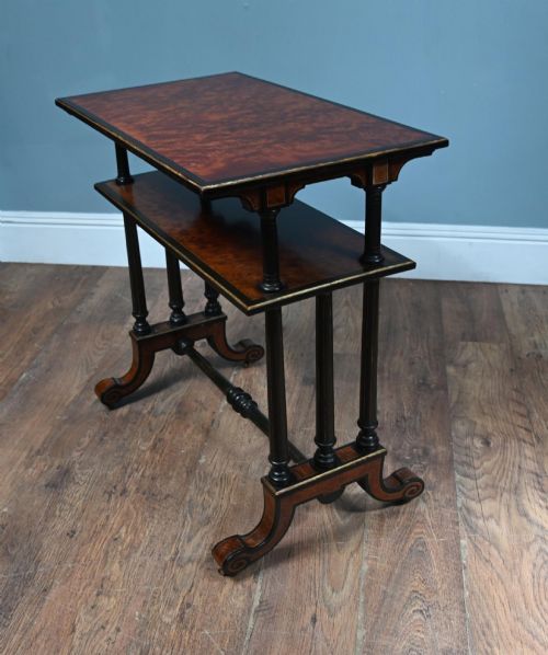 fig 2. A late Victorian two-tier dumb waiter with warm amboyna wood surfaces, ebonised turned column supports, and splayed legs on castors.