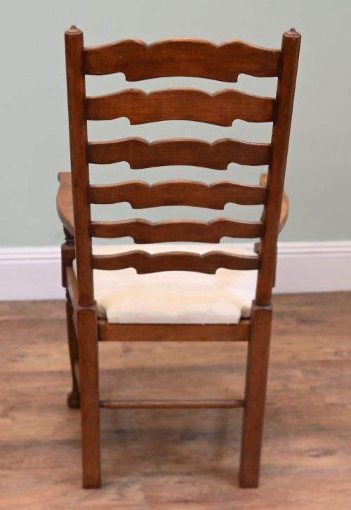 fig 1. A set of four Edwardian oak ladderback dining chairs featuring two armchairs and two side chairs with turned legs and cream fabric seats.