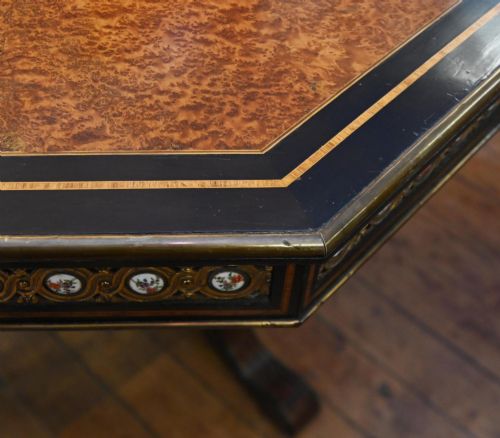fig 1. An octagonal Victorian centre table crafted from burr amboyna wood with ebonised borders and an apron decorated with porcelain roundels.