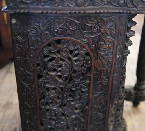 fig 1. A dark hardwood Burmese Davenport desk with pierced carved floral decoration, an openwork gallery, and a terracotta leather writing surface.