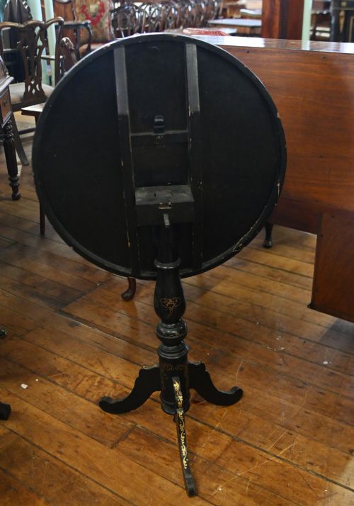 fig 1. A black lacquered circular tilt-top side table featuring a gilt dragon motif, supported on a turned central column and tripod pedestal legs.