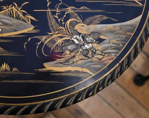 fig 1. A circular black lacquered side table featuring gilded Chinoiserie landscape motifs, bone inlay details, carved cabriole legs, and ball and claw feet.