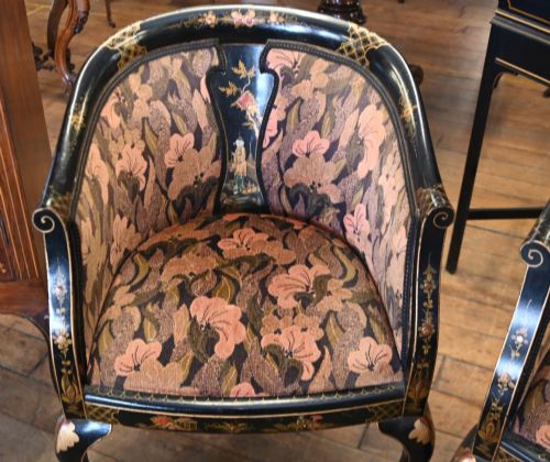 fig 2. A pair of black lacquered Chinoiserie armchairs featuring hand-painted gold detail, curved backs, pink floral upholstery, and cabriole legs.