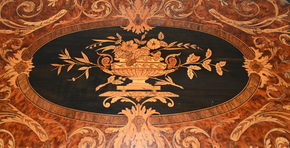 A 19th-century French Louis XV style centre table featuring a serpentine-edged top decorated with floral marquetry inlay, gilt-brass rim mounts, cabriole legs, and a single drawer. View IV