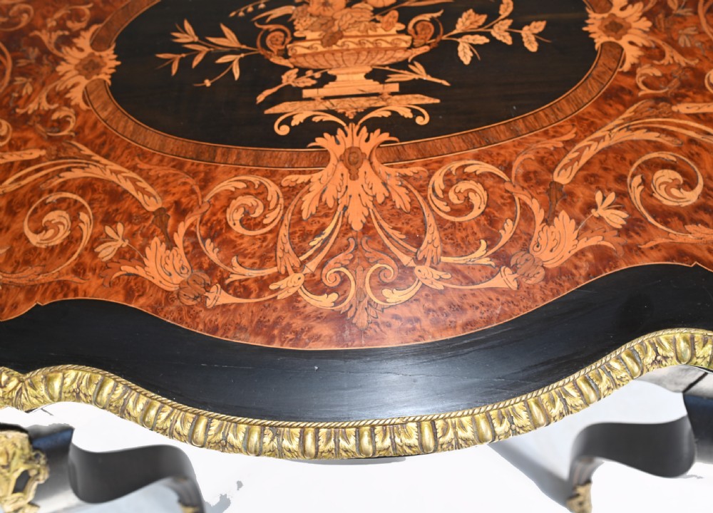 A 19th-century French Louis XV style centre table featuring a serpentine-edged top decorated with floral marquetry inlay, gilt-brass rim mounts, cabriole legs, and a single drawer. View V