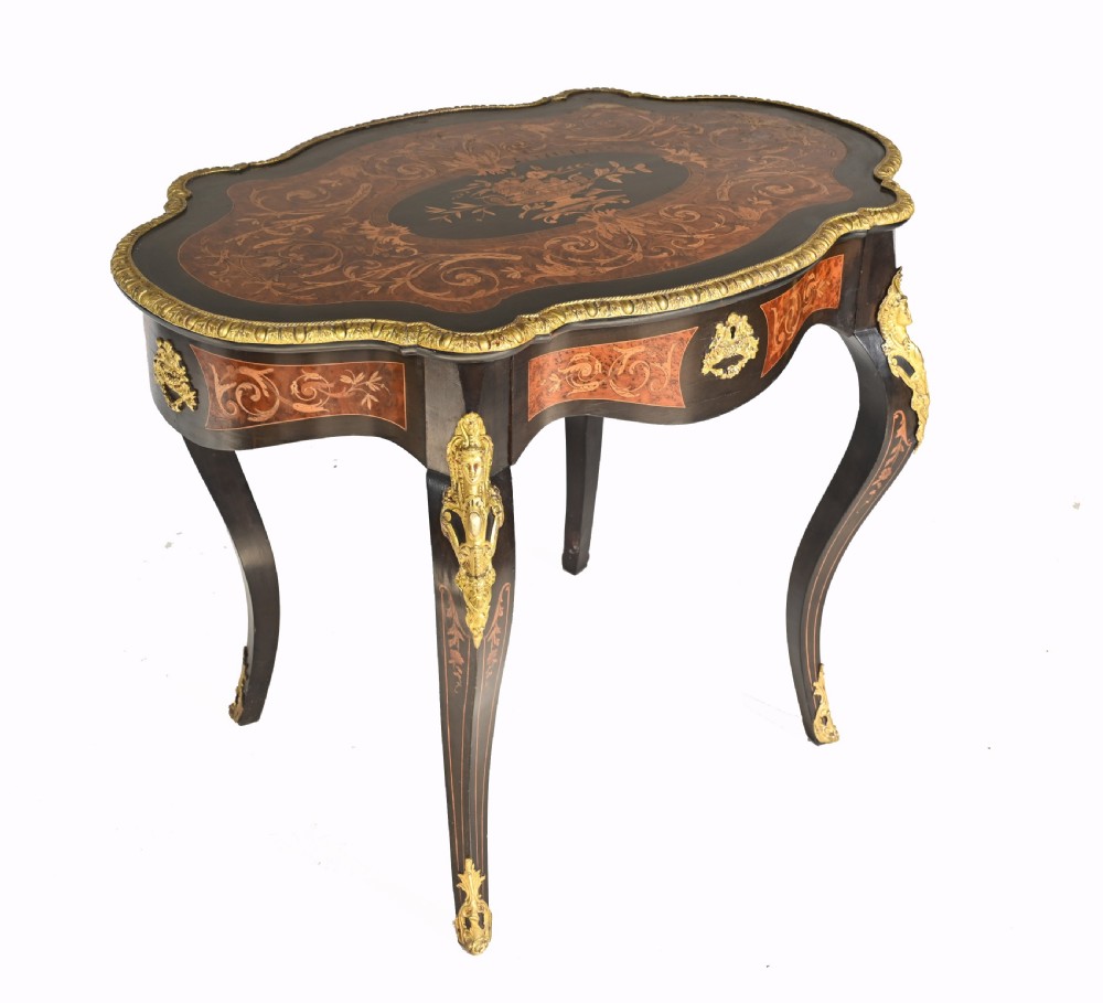 A 19th-century French Louis XV style centre table featuring a serpentine-edged top decorated with floral marquetry inlay, gilt-brass rim mounts, cabriole legs, and a single drawer. View VI